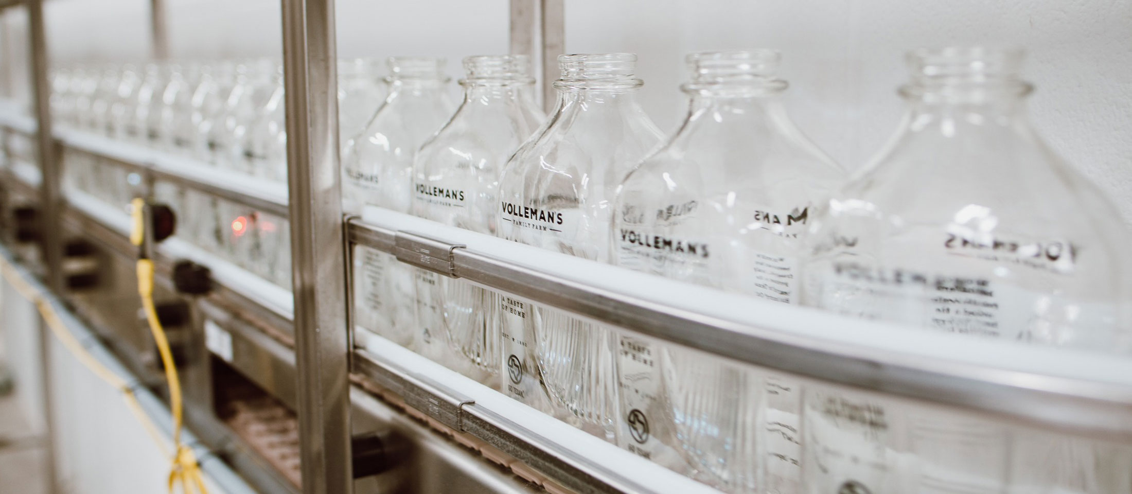 Botellas de vidrio en la línea de embotellado a punto de llenarse de leche